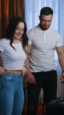 Bagajı olan genç bir çift. Güzel kadın ve yakışıklı adam otel odasından çıkmadan önce bavullarını tutuyorlar. Aile tatili. Dikey video