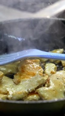 Kızartma tavasında et parçaları. Kızartma tavasında tavuk eti pişirmek. Lezzetli yemek hazırlığı. Yakın plan. Dikey video