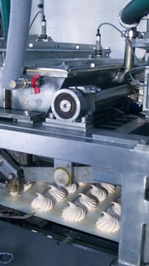 Karmaşık mekanizmalı otomatik makine çalışıyor ve marşmelov üretiyor. Modern gıda fabrikasındaki ekipmanlar. Dikey video