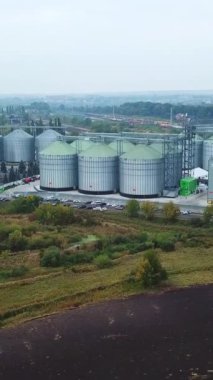 Modern tahıl ambarı bölgesinde sayısız metal asansör tankı var. İHA, tarlalarda bulunan büyük bir sanayi bölgesinden uzaklaşıyor. Dikey video
