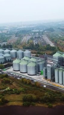 Tahıl depolama ve işleme için gümüş tarım asansörü tankları. Sanayi bölgesinde ve köyde devasa metal sarnıçları olan büyük bir fabrika. Dikey video