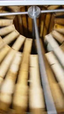 Bal toplama aparatında çalışıyorum. Çembere yerleştirilmiş bal çerçeveleri sağlıklı ürün elde etmek için santrifüj makinesinde dönüyor. Dikey video