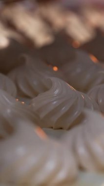 Şekil ve boyut olarak aynı beyaz kremalı şekerlemeler. Yiyecek fabrikasında üretilen vanilyalı zephyr. Kapatın. Dikey video