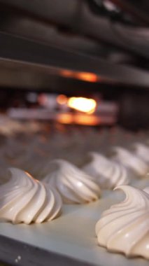 Taşıyıcı bant yeni yapılmış şekerlemeleri yavaşça taşıyor. Yiyecek fabrikasında kremalı şekerler üretiliyor. Kapatın. Güzel fon. Dikey video