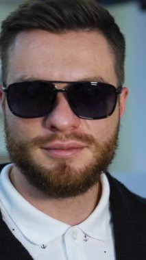Yakışıklı adam gözlüğü optik olarak seçiyor. Mağazada geniş çaplı modern göz eşyası çeşitleri var. Dikey video