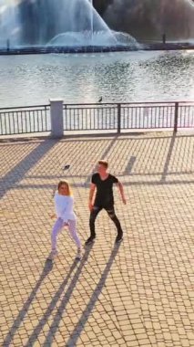 Nehir kenarında dans eden mutlu gençler Dikey video