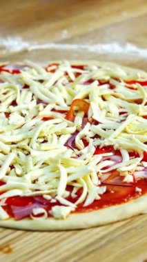 Peynirli, mantarlı, bakonlu ve domatesli yarı hazır pizza. Pizza fırında pişirilmeye hazır. Yemek video konsepti. Dikey video