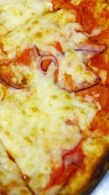 Lokantadaki lezzetli taze pizza. Pizza bıçağıyla parçalanmış fırından pizza yaptım. Üstü peynirli olsun. Dikey video