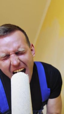 Duvarları boyayan komik bir zanaatkar. Oda yenileme çalışmaları sırasında boya silindirinde şarkı söylüyormuş gibi yapan neşeli genç erkek işçi. Dikey video