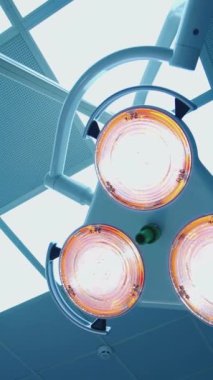 Tıbbi lambalar. Ameliyathanede parlak ışık. Hastanede aydınlatacak tıbbi malzemelerle dolu bir tavan. Yakın plan. Dikey video