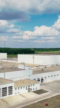 Yeşil ormanın yakınındaki modern endüstri. Gündüz vakti doğadaki büyük sanayi bölgesi. Kamera yükseliyor. İHA görüntüsü. Dikey video