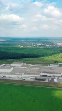 Kırsal kesimdeki sanayinin panoramik görüntüsü. Fabrika yeşil alanda. Doğada endüstriyel bitki. Hava görüntüsü. Dikey video