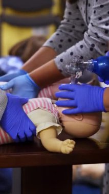 İlk yardım eğitimi alıyorum. Bebek mankenlere kardiyopulmoner resüsitasyon uygulayan pratisyenler. Göğüs sıkışması ve nefes alma alıştırması. Tıp eğitimi almış. Dikey video