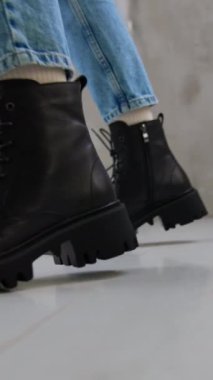 Kot pantolon ve beyaz çorap giyen manken siyah çizme gösterir. Dişiler için uygun soğuk hava ayakkabıları..