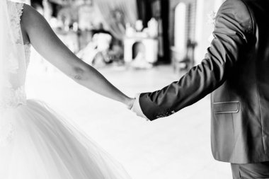 Kutlama sırasında bir düğün yerinde el ele tutuşan çift. Gelin ve damat el ele tutuşur, düğün törenlerinde birlikte vakit geçirirler..