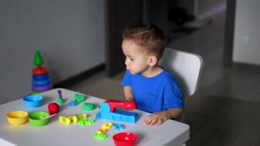 Küçük çocuk renkli oyuncaklarla oynuyor. Küçük çocuk için oyun eğitimi.