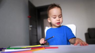 Kalemlerle resim yapan sevimli, oyuncu çocuk. Küçük şirin çocuk çizim konsepti.