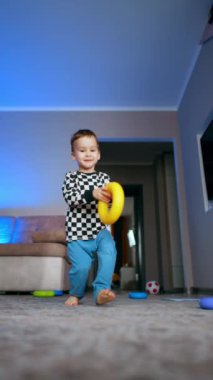 Renkli oyuncaklarla eğitici bir oyun. Yerde oyuncaklarla oynayan şirin bir çocuk. Dikey video.