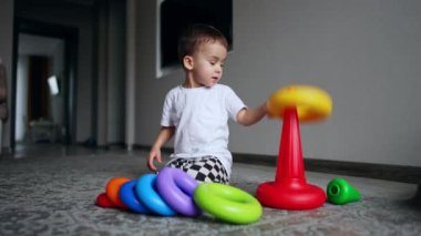 Okul öncesi eğlenceli oyun öğrenme. Küçük sevimli çocuk renkli oyuncaklarla oynuyor..