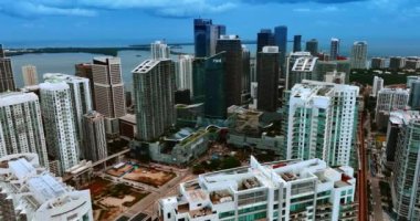 Miami, Florida, ABD 'deki yüksek binaların üzerine iniyor. Arkaplanda koyu mavi gökyüzünün altındaki su manzarası.