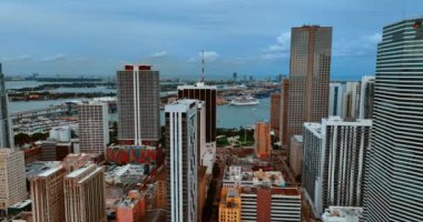 Yüksek binaların arasındaki insansız hava aracı görüntüleri ve su manzarasına yaklaşıyoruz. Miami, Florida, ABD 'de kasvetli bir günde.