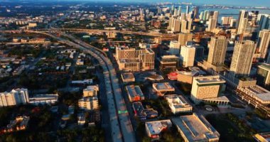 Gün batımında güneşli Miami 'nin güzel manzarası. İnsansız hava aracı otobanın üzerinden aşağı iniyor..