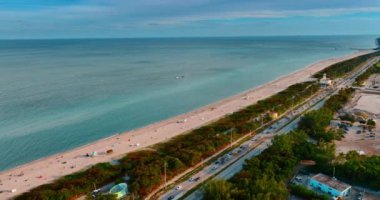 Atlantik Okyanusu 'nun kumlu plajı boyunca birden fazla arabası olan işlek bir otoyol. Miami, Florida, ABD 'deki kıyı manzarası.