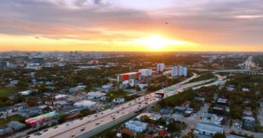 Uçak Miami, Florida, ABD panoramasının üstündeki renkli gökyüzünde uçuyor. Yukarıdan güzel gün batımı.