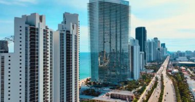 Atlantik Okyanusu kıyısındaki muhteşem modern gökdelenler. Miami Sahili 'nin güneşli manzarası. Arkaplanda güzel masmavi bir su manzarası var..