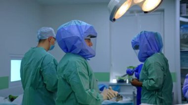 Koruyucu kask ve üniforma giyen cerrahi ekip ameliyathanede. Doktorlar travma ameliyatı yapmaya hazır..