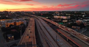 Otobanda çok az sayıda çok şeritli yol ve hareket halindeki arabalar var. Miami, Florida, ABD şehir manzarasının üzerindeki güzel pembe ve turuncu gökyüzü..