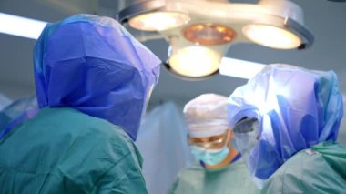 Operasyonda koruyucu kask takan cerrahlar. Travma ameliyatı yapan doktorlara düşük açılı bakış açısı.