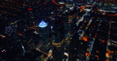 Geceleri gökdelenleri olan modern bir şehrin yukarısında. Parlak metropolün üstündeki insansız hava aracı görüntüleri. Philadelphia, Pennsylvania, ABD.