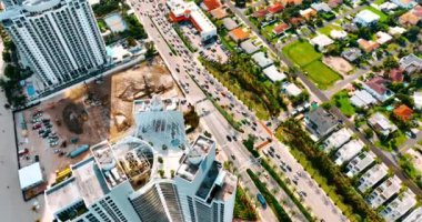 Güneşli bir günde sayısız araba Miami otobanından geçer. Bir gökdelenin yüksekliğinden drone görüntüleri.