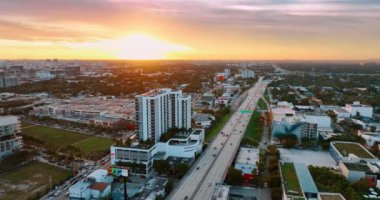 Günbatımında ABD 'de yeşil Miami, Florida' nın engin manzarası. Otobanın yukarısındaki drone görüntüleri ve geçen arabalar..