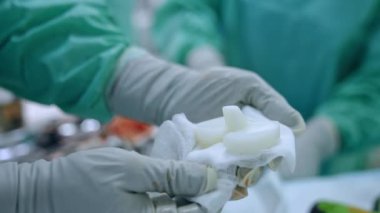 Doktorun elleri sargı bezindeki ortopedik implantı tutuyor. Kapatın. Bulanık arkaplan.