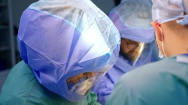 Hastayı koruyucu kasklı doktorlar ameliyat ediyor. Travma cerrahisinde işbirliği. Üst görünüm.