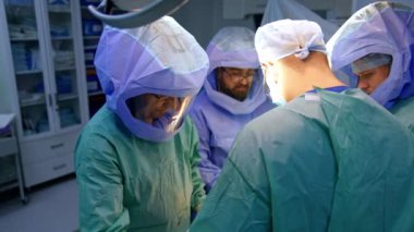 Tıbbi ekip tarafından yapılan travma ameliyatı. Hemşire aletleri geçirirken dört doktor hastayı ameliyat ediyor..