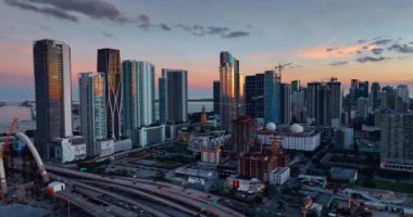 Miami, Florida, ABD şehir merkezindeki otobanların üzerinde yavaşça yükseliyor. Alacakaranlıktaki gökdelenlerin güzel manzarası.