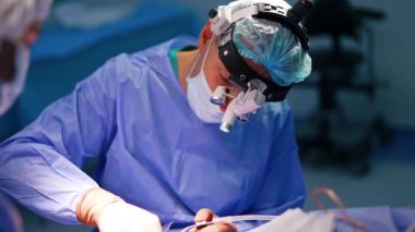 Operasyonda orta yaşlı erkek cerrah. Profesyonel gözlük takmak nörolojik işlemde araç kullanır.