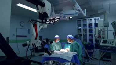 Cerrah ve asistan modern ameliyathanede çalışıyor. Doktora yardım etmek cerrahi standında araç ve cihazları düzenler.