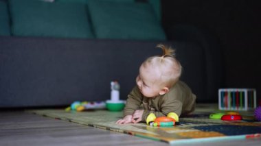 Beyaz erkek bebek yerde yatıyordu. Ayağa kalkmaya çalıştı ama başaramadı. Tatlı çocuk acı acı ağlamaya başlar..
