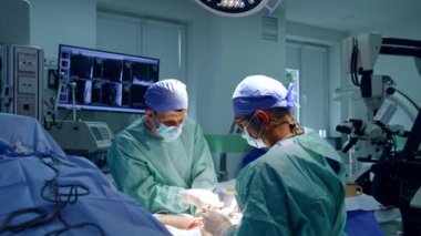 Elden ameliyat. Bir doktor ve asistan hastayı modern donanımlı bir odada ameliyat eder..