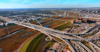Dallas, Teksas 'taki Margaret McDermott Köprüsü' ne giden otoyollardaki görüntüler. Arka planda Margaret Hunt Hill Köprüsü 'nün olduğu geniş şehir manzarası. Hava perspektifi.