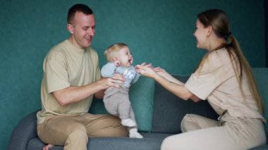 Baba karısına sevimli, gülümseyen bir bebek verir. Anne sevgili çocuğuyla oynuyor. Aile evde..