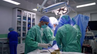Ameliyathanede tıbbi ekip çalışıyor. Travma ameliyatını koruyucu miğferli doktorlar gerçekleştiriyor..