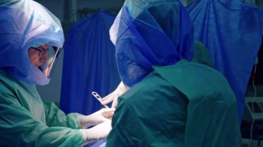 Koruyucu kask takan ortopedik cerrah ekibi artroskopik ameliyat gerçekleştiriyor. Prosedürdeki doktorların işbirliği.