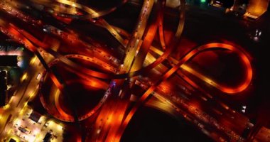 Sarı ve turuncu lambalar metropolün kavşağında otoyolları ve otobanları aydınlatıyor. Dallas yolları gece tepeden bakıldığında.