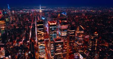 Geceleri New York 'un ışıl ışıl manzarası. Gökdelenlerin tepesinde neon ışıklı İHA görüntüleri.