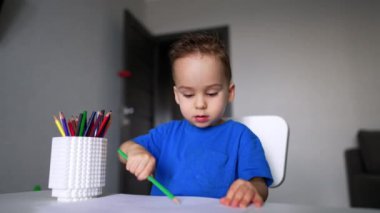 Tatlı çocuk çizime odaklanmış durumda. Evde resim yapan sevimli bir çocuk. Kapat..